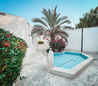 نمای سفید با حوض آبی در فضای بیرون هتل آبادگران کیش