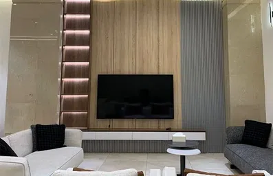 مبلمان راحتی با رنگ روشن و یک تلویزیون بزرگ در لابی هتل النبلا 2 نجف