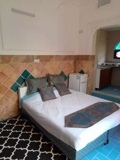 اتاق دو تخته با آشپزخانه با کف و دیوارهای کاشی شده در اقامتگاه عطاءالدوله شیراز