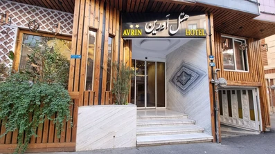 ورودی هتل 2 ستاره اورین تهران با نرده هایی چوبی و در شیشه ای اتومات