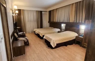 اتاق سه تخته با دکور چوبی در هتل اعیان مشهد