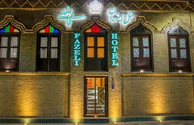 نمای ساختمان آجری هتل فاضلی یزد با پنجره های چوبی و رنگی سنتی
