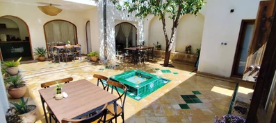 حیاط کوچک با یک حوض آبی در اقامتگاه سنتی گوشه شیراز