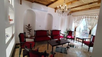 لابی اقامتگاه سنتی گوشه شیراز با یک دست مبل قرمز