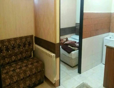 اتاق خواب  و مبل راحتی در کنار اشپزخانه