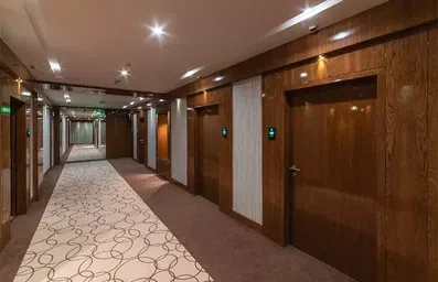 راهرو طبقات هتل جهان مشهد با دیوارها و درهای تمام چوب و کف موکت