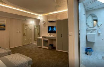 اتاق دو نفره با نمای سرویس بهداشتی در راست و تلویزیون در سمت چپ هتل نور الزهرا کربلا