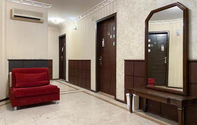 راهروی هتل آپارتمان پارتیکان اصفهان با آینه بزرگ و مبل قرمز