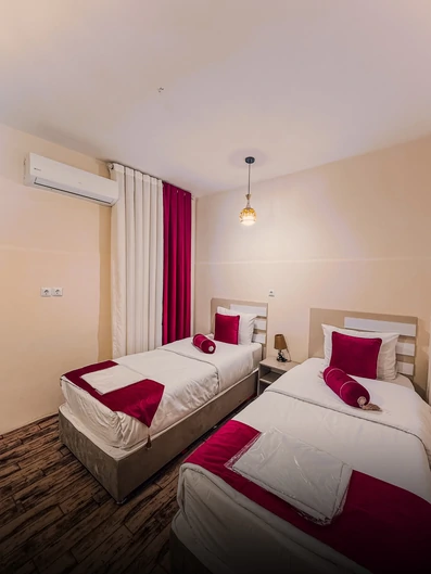 اتاق دو تخته با دکور سفید و قرمز در هتل آپارتمان پدر من بوشهر