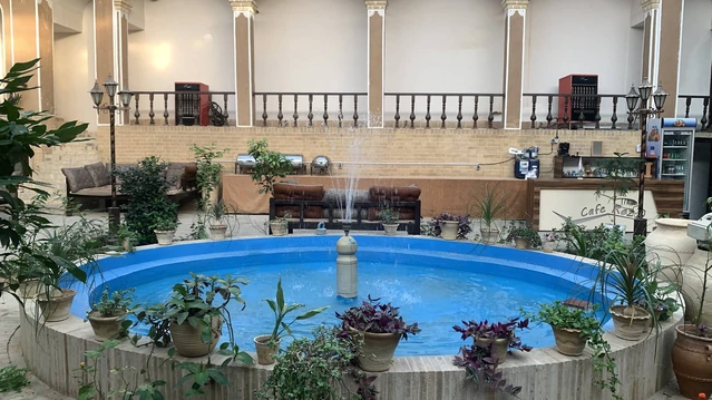 حیاط با حوض آبی بزرگ و تخت در هتل سنتی رز یزد