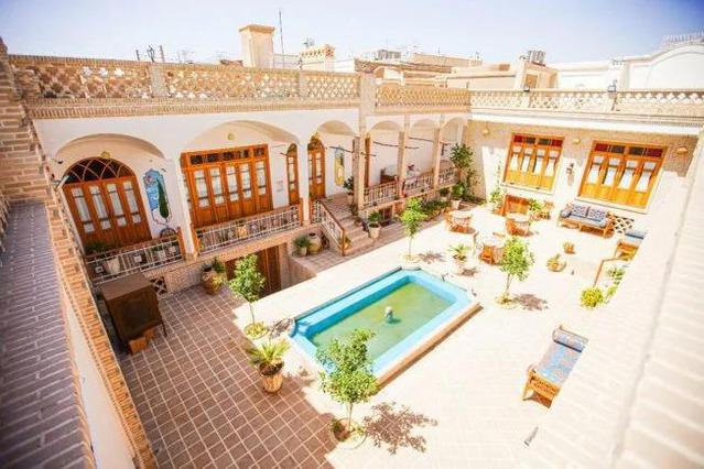 نمای بالا از یک حیاط قدیمی سنتی به سبک ایرانی با حوض زیبای مستطیل شکل در وسط آن در سرای سه سوک کاشان